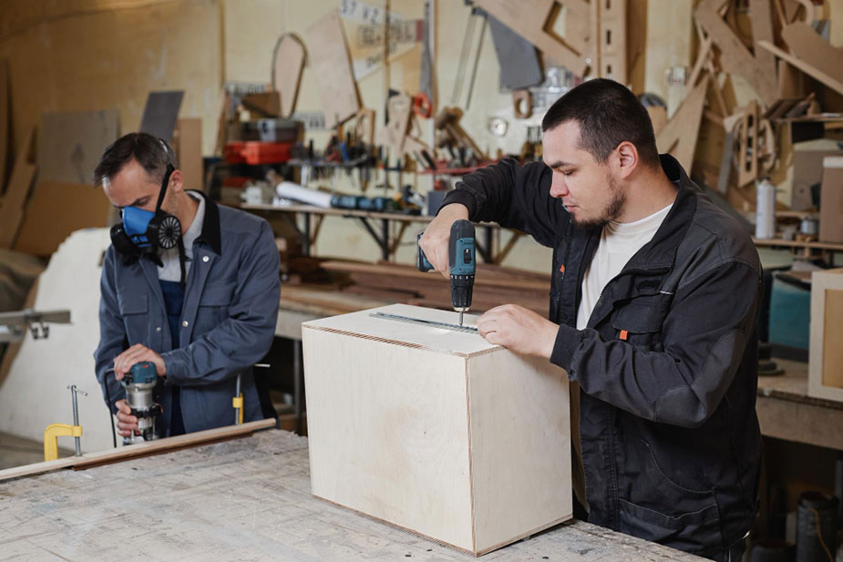 Radnici u procesu montaže drvenog nameštaja u stolarskoj radionici